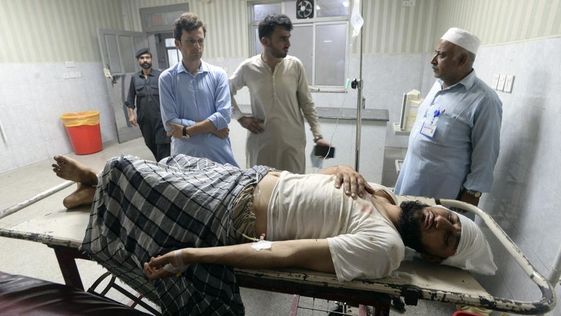 Seorang korban luka akibat ledakan bom dahsyat bersama kerabatnya setibanya di sebuah rumah sakit di Peshawar, Pakistan, Minggu, 30 Juli 2023. Sebuah bom mengoyak unjuk rasa pendukung ulama garis keras dan pemimpin politik di barat laut negara itu. Distrik Bajur yang berbatasan dengan Afghanistan pada Minggu, kata polisi dan pejabat kesehatan. (AP Photo/Muhammad Sajjad)