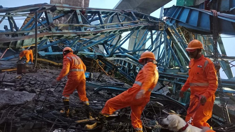 Petugas penyelamat mencari korban selamat dari sebuah crane runtuh saat pembangunan jembatan di distrik Thane di negara bagian barat Maharashtra, India, 1 Agustus 2023. (REUTERS/Stringer)