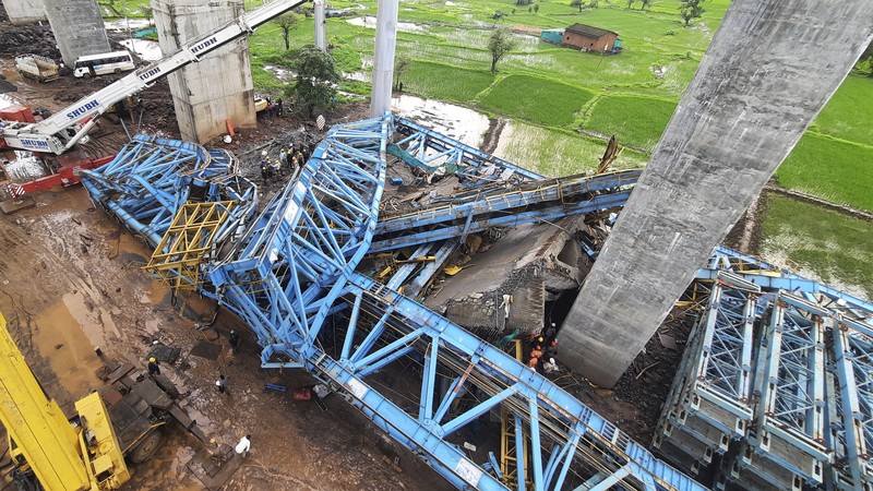 Petugas penyelamat mencari korban selamat dari sebuah crane runtuh saat pembangunan jembatan di distrik Thane di negara bagian barat Maharashtra, India, 1 Agustus 2023. (REUTERS/Stringer)
