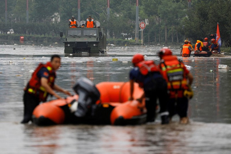 Petugas penyelamat bekerja untuk mengevakuasi penduduk yang terkena dampak banjir setelah sisa-sisa Topan Doksuri membawa hujan dan banjir di Beijing, China 2 Agustus 2023. (REUTERS/Tingshu Wang)