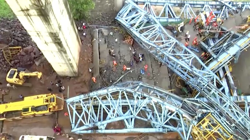 Petugas penyelamat mencari korban selamat dari sebuah crane runtuh saat pembangunan jembatan di distrik Thane di negara bagian barat Maharashtra, India, 1 Agustus 2023. (REUTERS/Stringer)