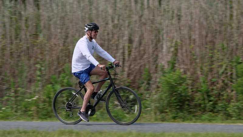 Presiden AS Joe Biden mengedari sepeda di Gordons Pond State Park, Pantai Rehoboth, Delaware, Amerika Serikat, Selasa (1/8/2023). (REUTERS/Leah Millis)