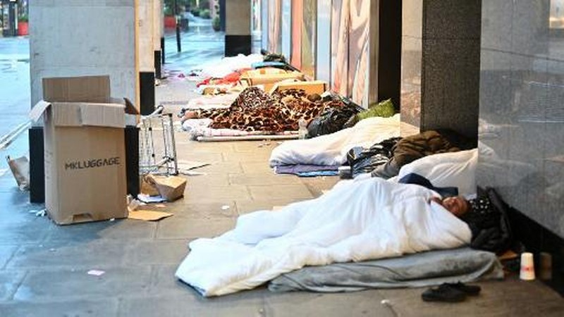 Orang-orang yang tidur di luar toko yang tutup di Oxford Street, Londoin, Inggris, Rabu (2/8/2023) waktu setempat. (JUSTIN TALLIS / AFP)
