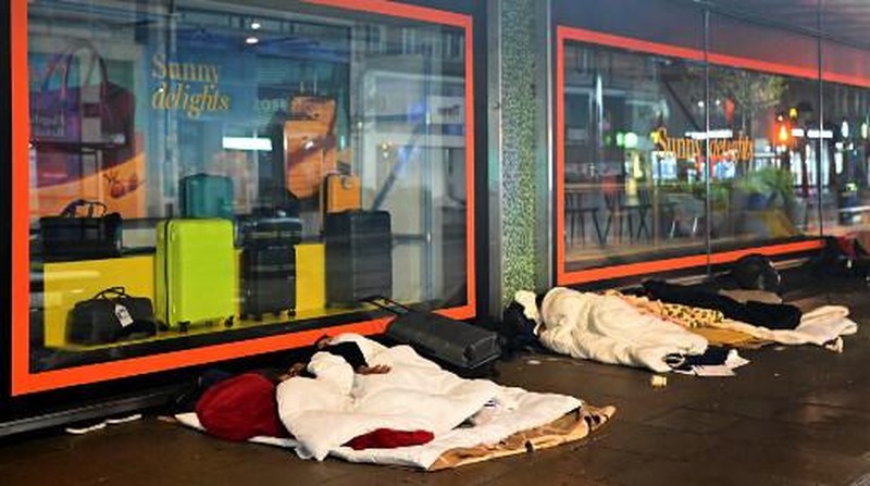 Orang-orang yang tidur di luar toko yang tutup di Oxford Street, Londoin, Inggris, Rabu (2/8/2023) waktu setempat. (JUSTIN TALLIS / AFP)