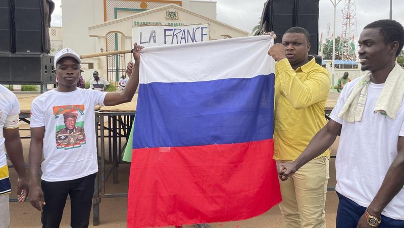 Pendukung junta yang berkuasa Niger memegang bendera Rusia pada awal protes yang menyerukan untuk memperjuangkan kebebasan negara dan menolak campur tangan asing di Niamey, Niger, Kamis, 3 Agustus 2023. Pawai jatuh pada kemerdekaan negara Afrika Barat hari dari mantan penguasa kolonialnya, Prancis, dan ketika sentimen anti-Prancis melonjak, lebih dari satu minggu setelah tentara yang memberontak menggulingkan presiden negara yang terpilih secara demokratis. (AP Photo/Sam Mednick)