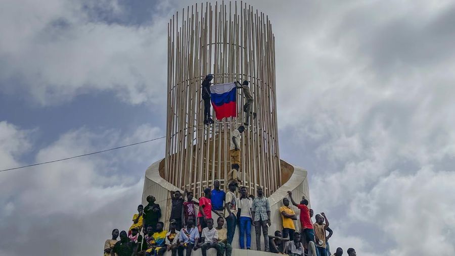 Pendukung junta yang berkuasa Niger memegang bendera Rusia pada awal protes yang menyerukan untuk memperjuangkan kebebasan negara dan menolak campur tangan asing di Niamey, Niger, Kamis, 3 Agustus 2023. Pawai jatuh pada kemerdekaan negara Afrika Barat hari dari mantan penguasa kolonialnya, Prancis, dan ketika sentimen anti-Prancis melonjak, lebih dari satu minggu setelah tentara yang memberontak menggulingkan presiden negara yang terpilih secara demokratis. (AP Photo/Sam Mednick)