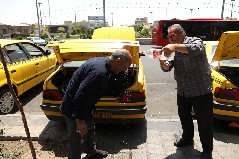 Turis berjalan di jalan selama gelombang panas di Teheran, Iran 2 Agustus 2023. (Majid Asgaripour/WANA (West Asia News Agency) via REUTERS)