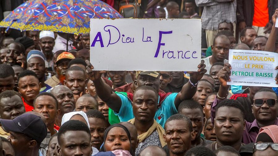 Ribuan pengunjuk rasa anti-sanksi berkumpul untuk mendukung tentara pemberontak di ibu kota Niamey, Niger 3 Agustus 2023. Tanda itu bertuliskan