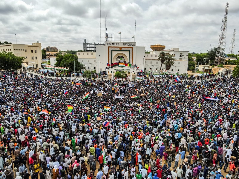Pendukung junta yang berkuasa Niger memegang bendera Rusia pada awal protes yang menyerukan untuk memperjuangkan kebebasan negara dan menolak campur tangan asing di Niamey, Niger, Kamis, 3 Agustus 2023. Pawai jatuh pada kemerdekaan negara Afrika Barat hari dari mantan penguasa kolonialnya, Prancis, dan ketika sentimen anti-Prancis melonjak, lebih dari satu minggu setelah tentara yang memberontak menggulingkan presiden negara yang terpilih secara demokratis. (AP Photo/Sam Mednick)