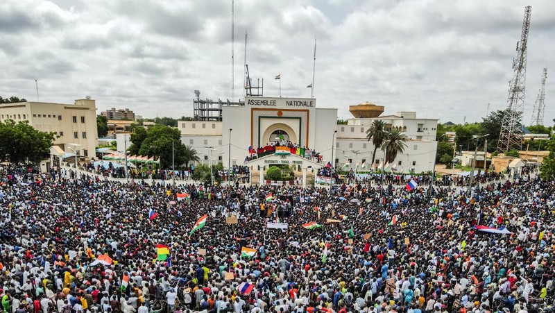 Pendukung junta yang berkuasa Niger memegang bendera Rusia pada awal protes yang menyerukan untuk memperjuangkan kebebasan negara dan menolak campur tangan asing di Niamey, Niger, Kamis, 3 Agustus 2023. Pawai jatuh pada kemerdekaan negara Afrika Barat hari dari mantan penguasa kolonialnya, Prancis, dan ketika sentimen anti-Prancis melonjak, lebih dari satu minggu setelah tentara yang memberontak menggulingkan presiden negara yang terpilih secara demokratis. (AP Photo/Sam Mednick)
