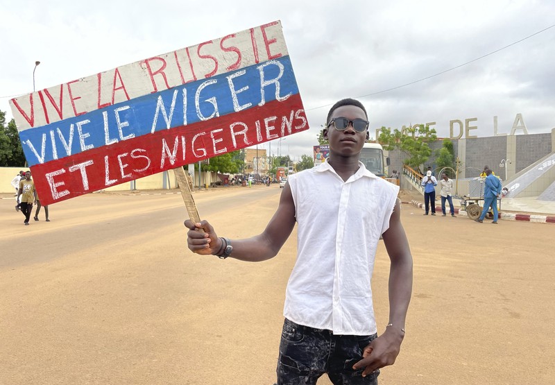 Pendukung junta yang berkuasa Niger memegang bendera Rusia pada awal protes yang menyerukan untuk memperjuangkan kebebasan negara dan menolak campur tangan asing di Niamey, Niger, Kamis, 3 Agustus 2023. Pendukung junta yang berkuasa Niger memegang bendera Rusia pada awal protes yang menyerukan untuk memperjuangkan kebebasan negara dan menolak campur tangan asing di Niamey, Niger, Kamis, 3 Agustus 2023. Pawai jatuh pada kemerdekaan negara Afrika Barat hari dari mantan penguasa kolonialnya, Prancis, dan ketika sentimen anti-Prancis melonjak, lebih dari satu minggu setelah tentara yang memberontak menggulingkan presiden negara yang terpilih secara demokratis. (AP Photo/Sam Mednick)