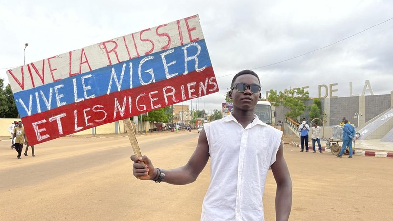 Pendukung junta yang berkuasa Niger memegang bendera Rusia pada awal protes yang menyerukan untuk memperjuangkan kebebasan negara dan menolak campur tangan asing di Niamey, Niger, Kamis, 3 Agustus 2023. Pawai jatuh pada kemerdekaan negara Afrika Barat hari dari mantan penguasa kolonialnya, Prancis, dan ketika sentimen anti-Prancis melonjak, lebih dari satu minggu setelah tentara yang memberontak menggulingkan presiden negara yang terpilih secara demokratis. (AP Photo/Sam Mednick)