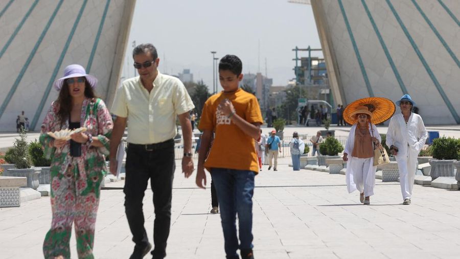 Turis berjalan di jalan selama gelombang panas di Teheran, Iran 2 Agustus 2023. (Majid Asgaripour/WANA (West Asia News Agency) via REUTERS)