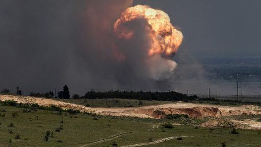 A picture shows detonation of ammunition caused by a fire at a military training field in the Kirovsky district of Crimea on July 19, 2023. Russian President Vladimir Putin has been informed about a fire at a military site in Moscow-annexed Crimea that forced authorities to evacuate thousands of civilians on July 19, 2023, the Kremlin said. News of the blaze came two days after Ukraine used waterborne drones to attack the Kerch bridge, a key military supply artery from mainland Russia to annexed Crimea. Authorities ordered the evacuation of over 2,000 residents from areas near the military field. A section of the Tavrida highway -- connecting the eastern Crimean port of Kerch to the port of Sevastopol on the peninsula's Black Sea coast -- was closed due to the fire. (Photo by Viktor KOROTAYEV / Kommersant Photo / AFP) / Russia OUT