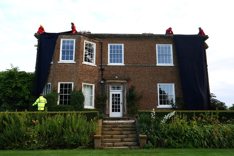 Rumah pribadi Perdana Menteri (PM) Inggris Rishi Sunak yang belokasi di Yorkshire, Inggris, Kamis (3/8/2023) waktu setempat ditutupi dengan kain hitam. (Greenpeace/Handout via REUTERS)