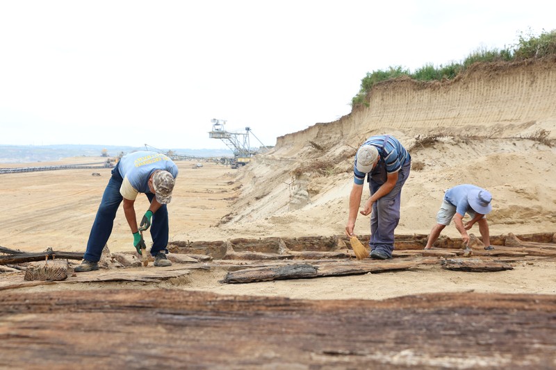 Arkeolog menggali lambung kapal kayu, sebuah kapal Romawi kuno dengan lambung datar di kota kuno Viminacium, dekat Kostolac, Serbia, 2 Agustus 2023. (REUTERS/Zorana Jevtic)
