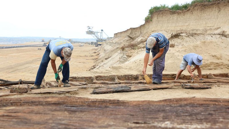 Arkeolog menggali lambung kapal kayu, sebuah kapal Romawi kuno dengan lambung datar di kota kuno Viminacium, dekat Kostolac, Serbia, 2 Agustus 2023. (REUTERS/Zorana Jevtic)