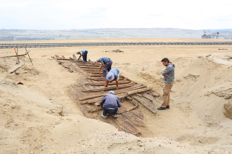 Arkeolog menggali lambung kapal kayu, sebuah kapal Romawi kuno dengan lambung datar di kota kuno Viminacium, dekat Kostolac, Serbia, 2 Agustus 2023. (REUTERS/Zorana Jevtic)