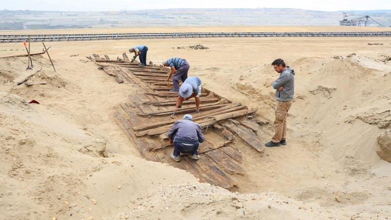 Arkeolog menggali lambung kapal kayu, sebuah kapal Romawi kuno dengan lambung datar di kota kuno Viminacium, dekat Kostolac, Serbia, 2 Agustus 2023. (REUTERS/Zorana Jevtic)