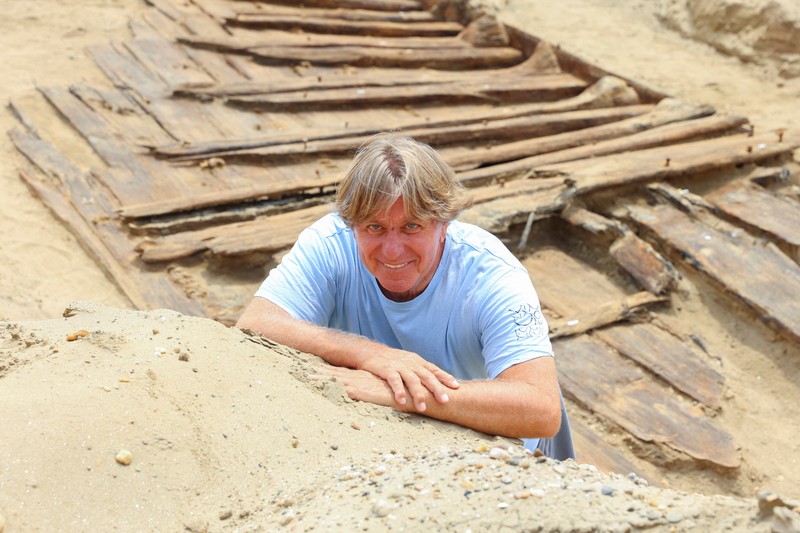 Arkeolog menggali lambung kapal kayu, sebuah kapal Romawi kuno dengan lambung datar di kota kuno Viminacium, dekat Kostolac, Serbia, 2 Agustus 2023. (REUTERS/Zorana Jevtic)