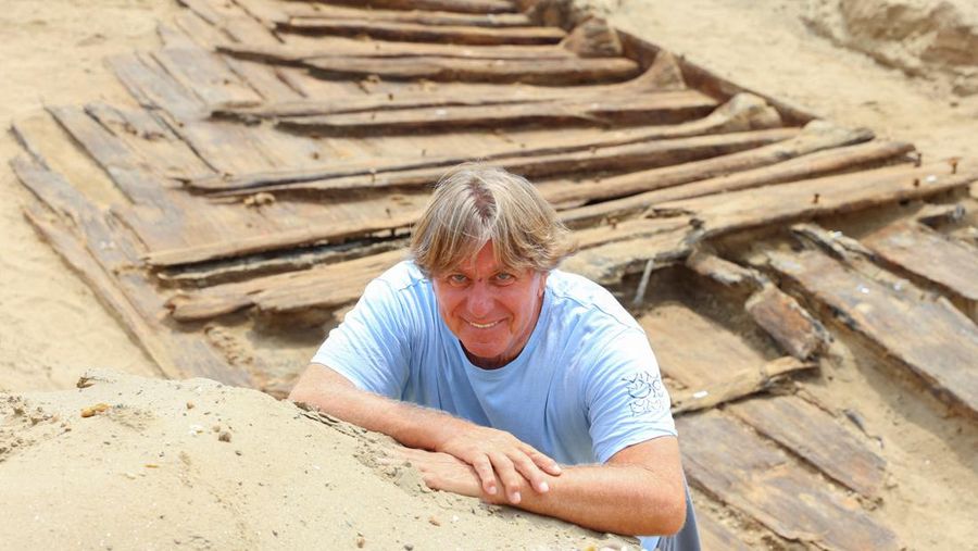 Arkeolog menggali lambung kapal kayu, sebuah kapal Romawi kuno dengan lambung datar di kota kuno Viminacium, dekat Kostolac, Serbia, 2 Agustus 2023. (REUTERS/Zorana Jevtic)