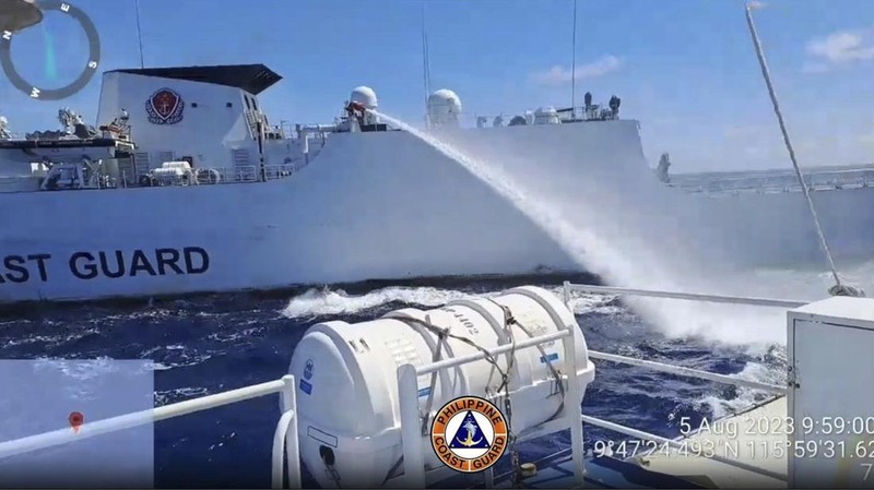 Dalam foto selebaran yang disediakan oleh Penjaga Pantai Filipina ini, sebuah kapal penjaga pantai China menggunakan kanon air di atas kapal Penjaga Pantai Filipina di dekat Second Thomas Shoal yang diduduki Filipina, Laut China Selatan saat mereka memblokir jalurnya selama misi pasokan ulang pada hari Sabtu 5 Agustus 2023. Militer Filipina mengutuk pada hari Minggu penggunaan meriam air yang 