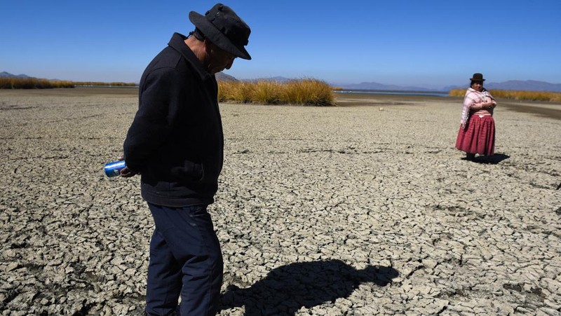 Isabel Apaza dan Gabriel Flores menaiki perahu mereka melalui jalur air sempit di dekat pantai Danau Titicaca pada musim kemarau di Huarina, Bolivia 3 Agustus 2023. (REUTERS/Claudia Morales)