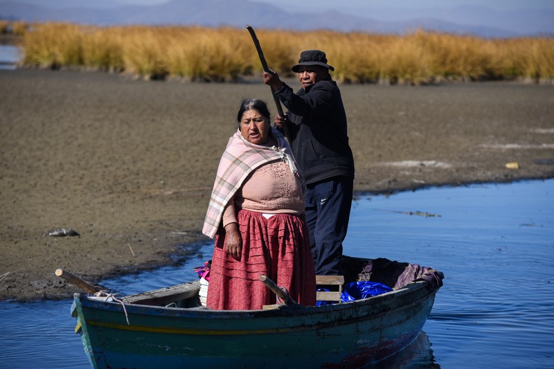 Isabel Apaza dan Gabriel Flores menaiki perahu mereka melalui jalur air sempit di dekat pantai Danau Titicaca pada musim kemarau di Huarina, Bolivia 3 Agustus 2023. Isabel Apaza dan Gabriel Flores menaiki perahu mereka melalui jalur air sempit di dekat pantai Danau Titicaca pada musim kemarau di Huarina, Bolivia 3 Agustus 2023. (REUTERS/Claudia Morales)