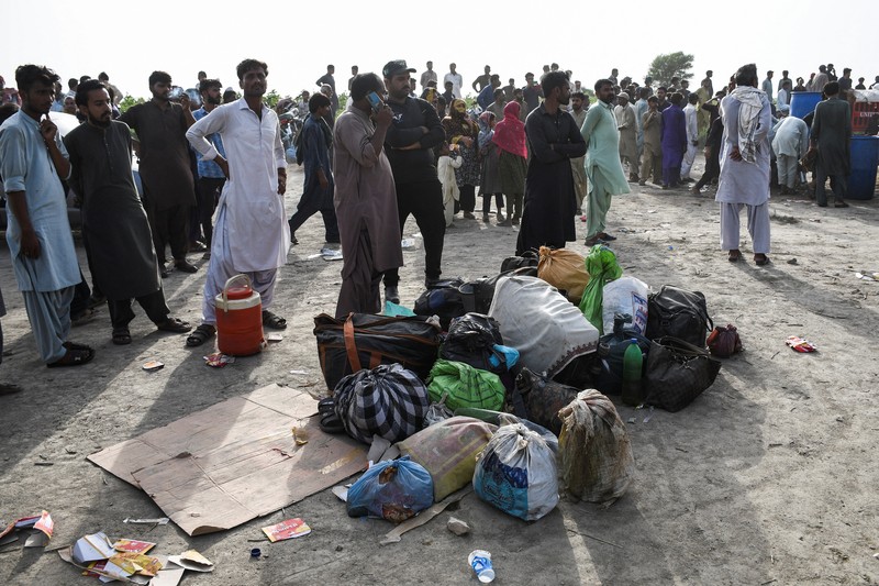 Petugas polisi berkumpul di lokasi kereta tergelincir di kota Sarhari di distrik Sanghar, Pakistan 6 Agustus 2023. (REUTERS/Yasir Rajput)