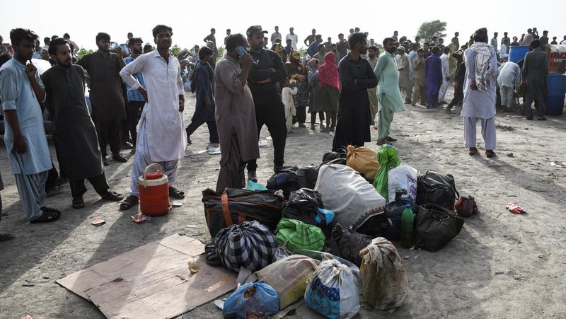 Petugas polisi berkumpul di lokasi kereta tergelincir di kota Sarhari di distrik Sanghar, Pakistan 6 Agustus 2023. (REUTERS/Yasir Rajput)