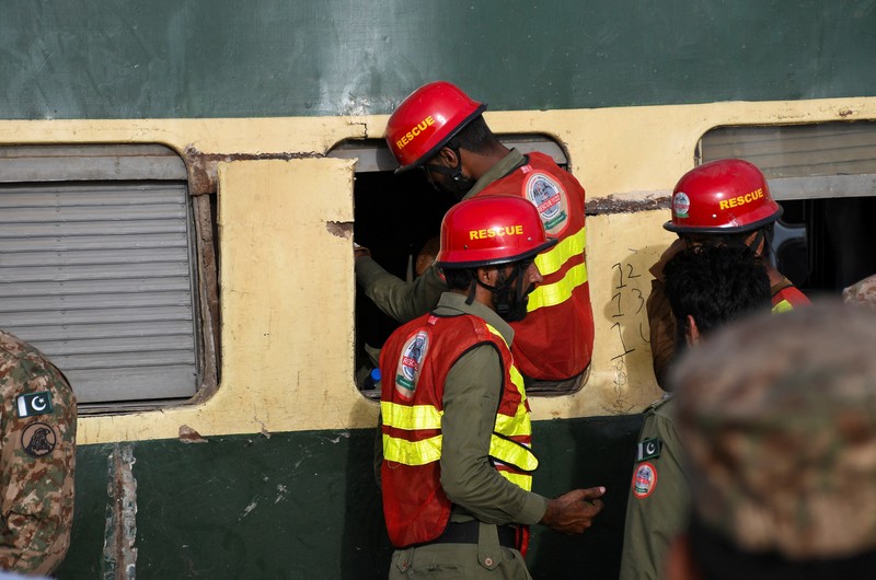 Petugas polisi berkumpul di lokasi kereta tergelincir di kota Sarhari di distrik Sanghar, Pakistan 6 Agustus 2023. Petugas polisi berkumpul di lokasi kereta tergelincir di kota Sarhari di distrik Sanghar, Pakistan 6 Agustus 2023. (REUTERS/Yasir Rajput)