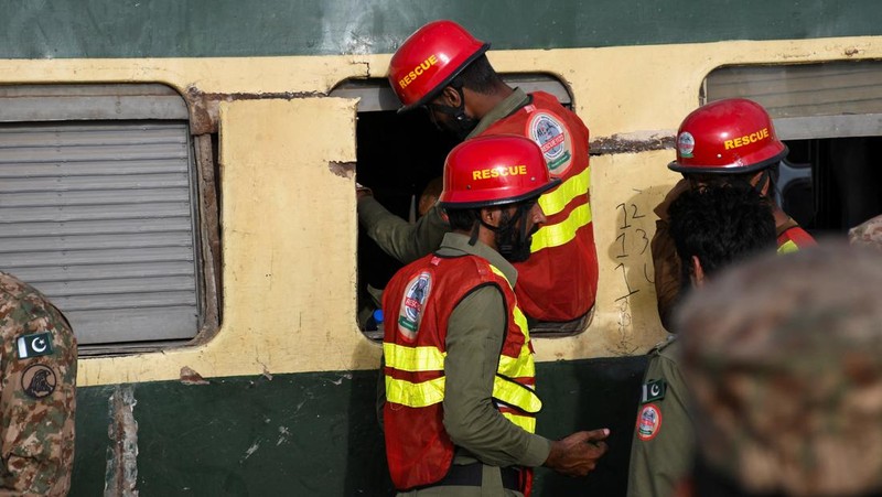 Petugas polisi berkumpul di lokasi kereta tergelincir di kota Sarhari di distrik Sanghar, Pakistan 6 Agustus 2023. (REUTERS/Yasir Rajput)