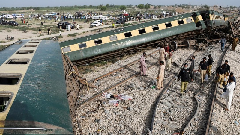 Petugas polisi berkumpul di lokasi kereta tergelincir di kota Sarhari di distrik Sanghar, Pakistan 6 Agustus 2023. (REUTERS/Yasir Rajput)
