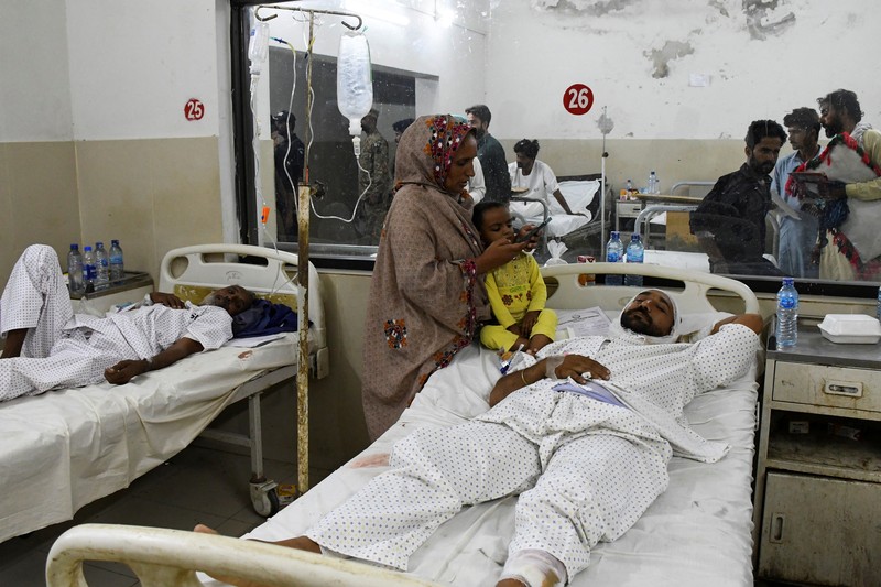 Petugas polisi berkumpul di lokasi kereta tergelincir di kota Sarhari di distrik Sanghar, Pakistan 6 Agustus 2023. (REUTERS/Yasir Rajput)
