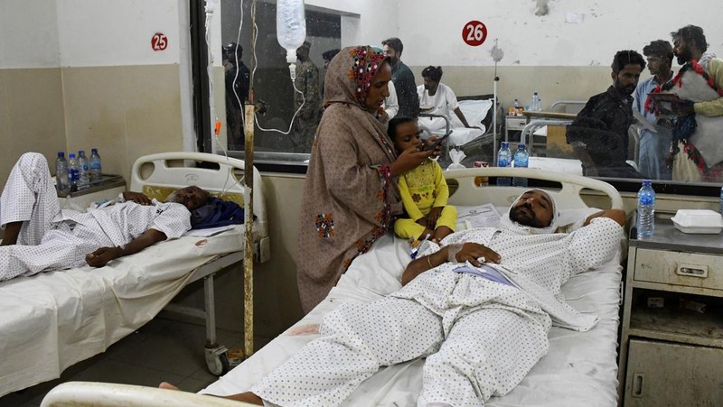 Petugas polisi berkumpul di lokasi kereta tergelincir di kota Sarhari di distrik Sanghar, Pakistan 6 Agustus 2023. (REUTERS/Yasir Rajput)