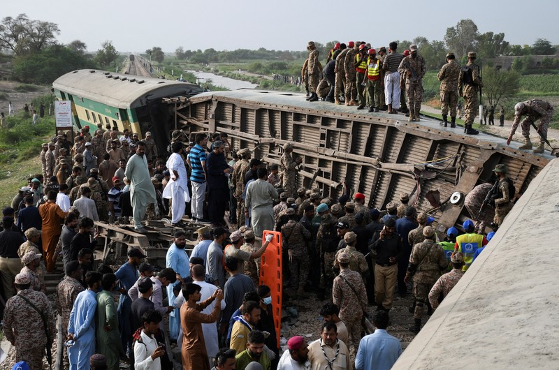 Petugas polisi berkumpul di lokasi kereta tergelincir di kota Sarhari di distrik Sanghar, Pakistan 6 Agustus 2023. Petugas polisi berkumpul di lokasi kereta tergelincir di kota Sarhari di distrik Sanghar, Pakistan 6 Agustus 2023. (REUTERS/Yasir Rajput)