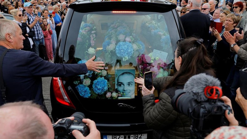 A hearse carrying the coffin of late Irish singer Sinead O'Connor passes outside her former home during her funeral procession as fans line the street to say their last goodbye to her, in Bray, Ireland, August 8, 2023. REUTERS/Clodagh Kilcoyne