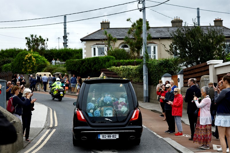 A hearse carrying the coffin of late Irish singer Sinead O'Connor passes outside her former home during her funeral procession as fans line the street to say their last goodbye to her, in Bray, Ireland, August 8, 2023. REUTERS/Clodagh Kilcoyne