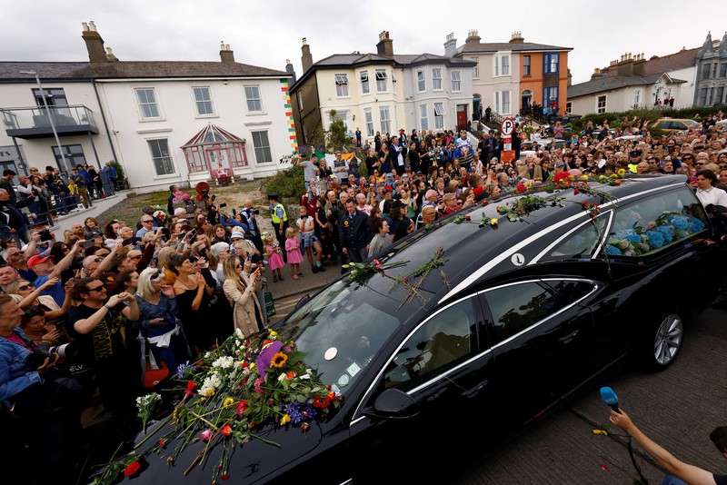PEOPLE-SINEADOCONNOR/FUNERAL A hearse carrying the coffin of late Irish singer Sinead O'Connor passes outside her former home during her funeral procession as fans line the street to say their last goodbye to her, in Bray, Ireland, August 8, 2023. REUTERS/Clodagh Kilcoyne