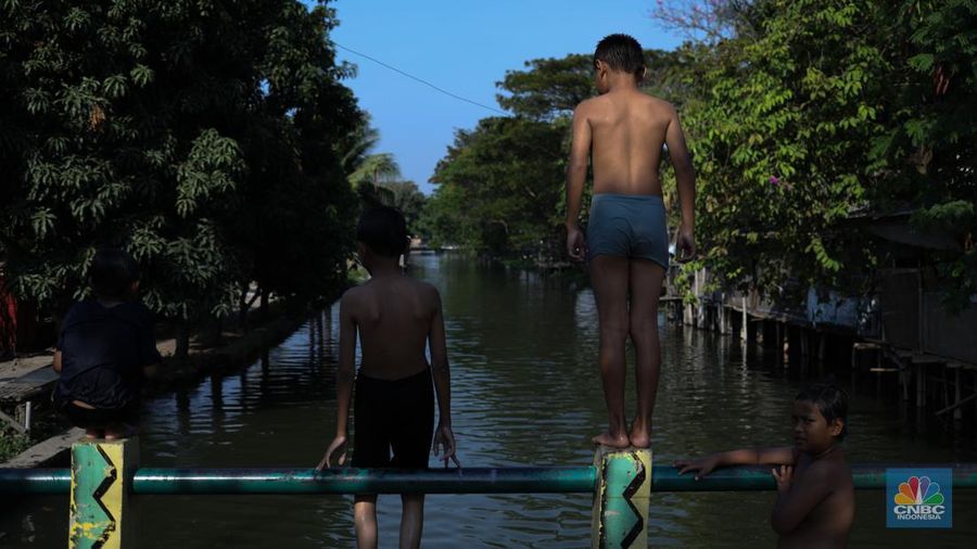Sejumlah anak-anak bermain air di saluran anak kali Cisadane, Desa Belimbing, Kecamatan Pasar Kemis, Kabupaten Tangerang, Banten, Rabu (9/8/2023). (CNBC Indonesia/Tri Susilo)