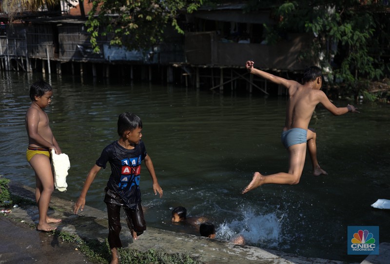 Sejumlah anak-anak bermain air di saluran anak kali Cisadane, Desa Belimbing, Kecamatan Pasar Kemis, Kabupaten Tangerang, Banten, Rabu (9/8/2023). Sejumlah anak-anak bermain air di saluran anak kali Cisadane, Desa Belimbing, Kecamatan Pasar Kemis, Kabupaten Tangerang, Banten, Rabu (9/8/2023). (CNBC Indonesia/Tri Susilo)