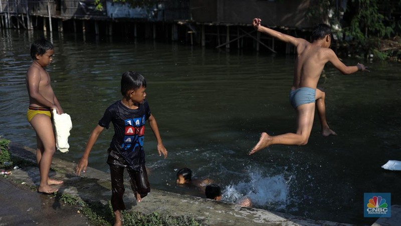 Sejumlah anak-anak bermain air di saluran anak kali Cisadane, Desa Belimbing, Kecamatan Pasar Kemis, Kabupaten Tangerang, Banten, Rabu (9/8/2023). (CNBC Indonesia/Tri Susilo)
