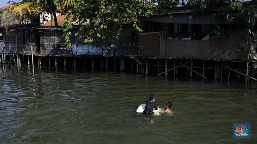 Sejumlah anak-anak bermain air di saluran anak kali Cisadane, Desa Belimbing, Kecamatan Pasar Kemis, Kabupaten Tangerang, Banten, Rabu (9/8/2023). (CNBC Indonesia/Tri Susilo)