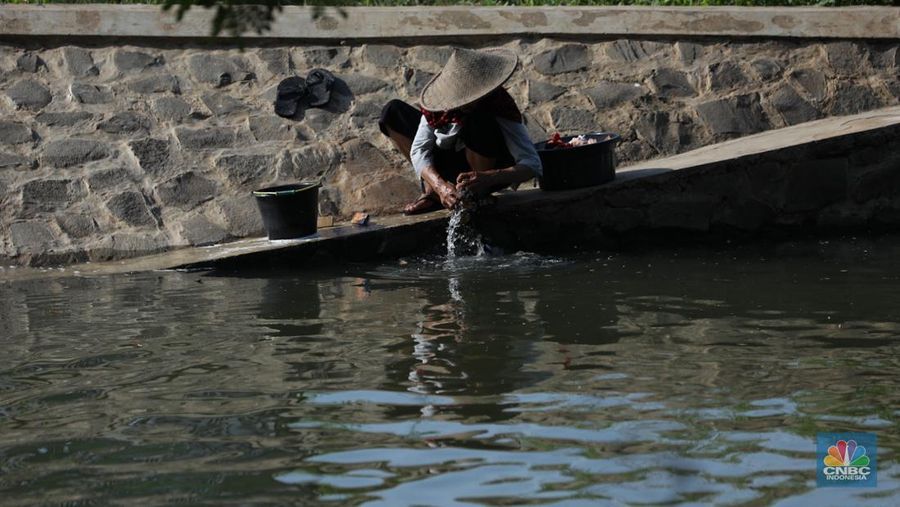 Sejumlah anak-anak bermain air di saluran anak kali Cisadane, Desa Belimbing, Kecamatan Pasar Kemis, Kabupaten Tangerang, Banten, Rabu (9/8/2023). (CNBC Indonesia/Tri Susilo)