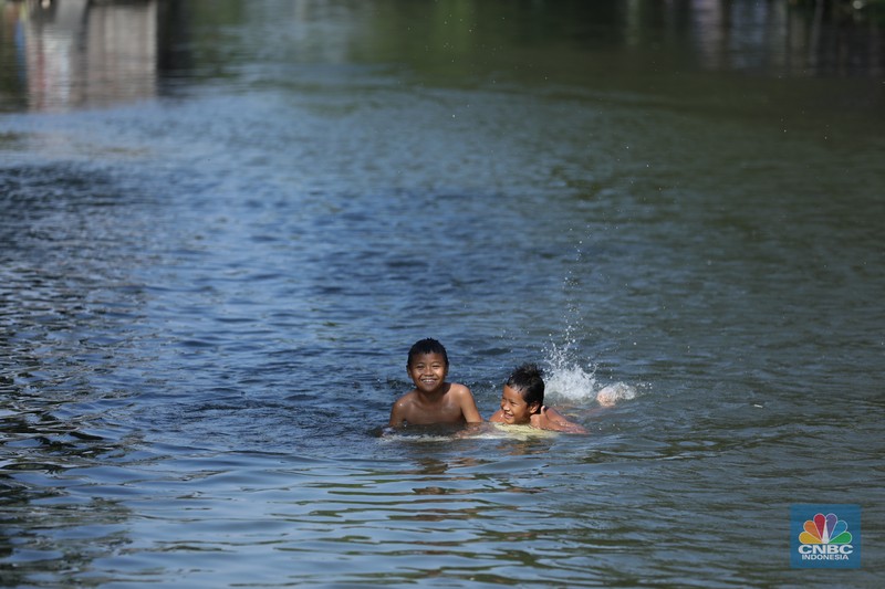 Sejumlah anak-anak bermain air di saluran anak kali Cisadane, Desa Belimbing, Kecamatan Pasar Kemis, Kabupaten Tangerang, Banten, Rabu (9/8/2023). Sejumlah anak-anak bermain air di saluran anak kali Cisadane, Desa Belimbing, Kecamatan Pasar Kemis, Kabupaten Tangerang, Banten, Rabu (9/8/2023). (CNBC Indonesia/Tri Susilo)