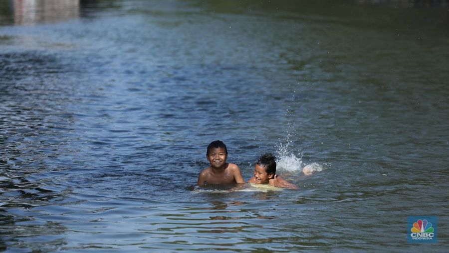 Sejumlah anak-anak bermain air di saluran anak kali Cisadane, Desa Belimbing, Kecamatan Pasar Kemis, Kabupaten Tangerang, Banten, Rabu (9/8/2023). (CNBC Indonesia/Tri Susilo)