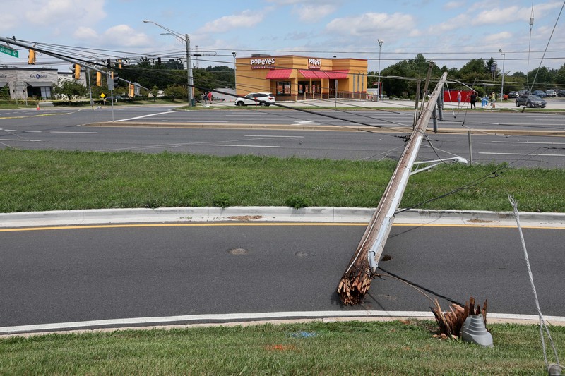 A downed power line that fell on an SUV can be seen the day after a powerful storm swept the region along Baltimore Blvd in Westminster, Maryland, U.S., August 8, 2023. REUTERS/Leah Millis