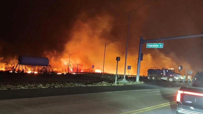 Orang-orang menyaksikan asap dan api memenuhi udara dari amukan kebakaran hutan di Front Street di pusat kota Lahaina, Maui pada Selasa, 8 Agustus 2023. Para pejabat Maui mengatakan kebakaran di kota bersejarah itu telah menghanguskan sebagian dari salah satu kawasan wisata paling populer di Hawaii. . Juru bicara County of Maui, Mahina Martin mengatakan dalam sebuah wawancara telepon pada Rabu pagi, kebakaran meluas di Lahaina, termasuk Front Street, area kota yang populer dengan turis. (Alan Dickar via AP)