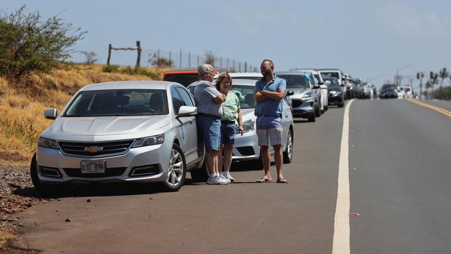 Orang-orang menyaksikan asap dan api memenuhi udara dari amukan kebakaran hutan di Front Street di pusat kota Lahaina, Maui pada Selasa, 8 Agustus 2023. Para pejabat Maui mengatakan kebakaran di kota bersejarah itu telah menghanguskan sebagian dari salah satu kawasan wisata paling populer di Hawaii. . Juru bicara County of Maui, Mahina Martin mengatakan dalam sebuah wawancara telepon pada Rabu pagi, kebakaran meluas di Lahaina, termasuk Front Street, area kota yang populer dengan turis. (Alan Dickar via AP)