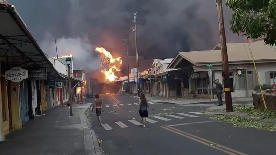 Orang-orang menyaksikan asap dan api memenuhi udara dari amukan kebakaran hutan di Front Street di pusat kota Lahaina, Maui pada Selasa, 8 Agustus 2023. Para pejabat Maui mengatakan kebakaran di kota bersejarah itu telah menghanguskan sebagian dari salah satu kawasan wisata paling populer di Hawaii. . Juru bicara County of Maui, Mahina Martin mengatakan dalam sebuah wawancara telepon pada Rabu pagi, kebakaran meluas di Lahaina, termasuk Front Street, area kota yang populer dengan turis. (Alan Dickar via AP)